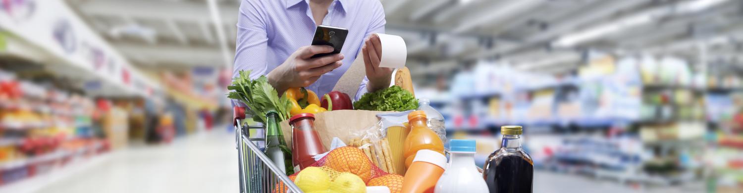 Une personne pousse un caddie dans un supermarché