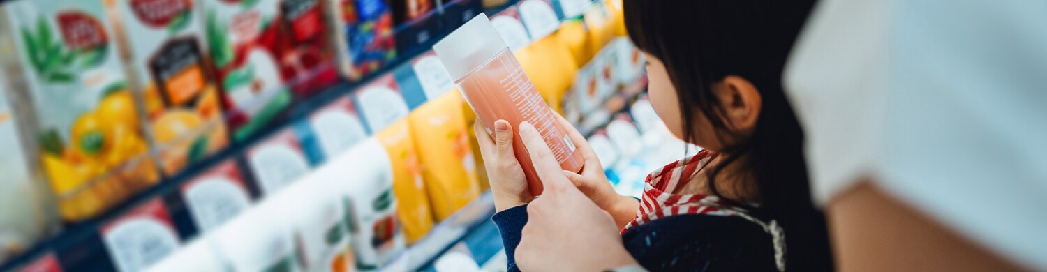 rayon de boissons fraiches, une enfant regarde une boisson avec son parent