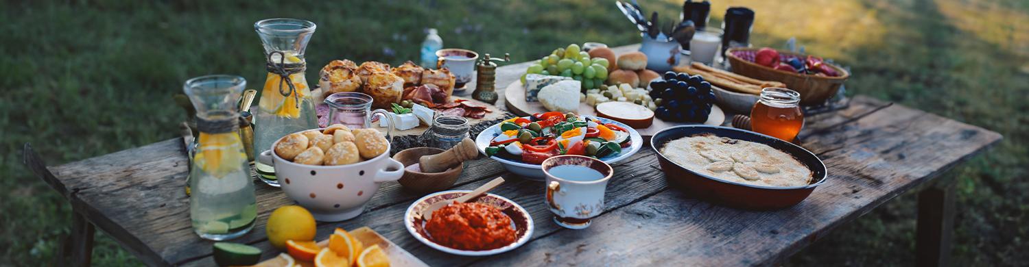 table en bois dans la campagne, avec de nombreux plats dessus