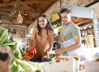 un couple choisit des légumes dans un magasin bio