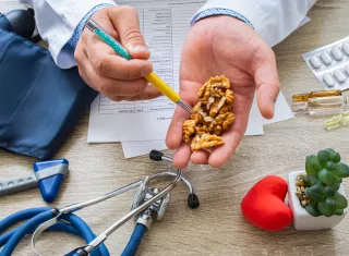 Un médecin tient des noix dans le creux de sa main