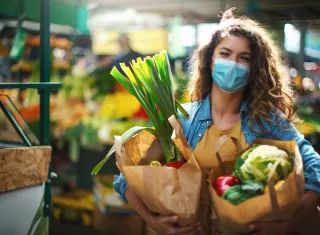 Une femme portant un masque chirurgical fait ses courses