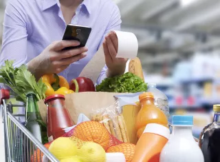 Une personne pousse un caddie dans un supermarché