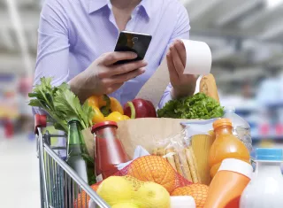 Une personne pousse un caddie dans un supermarché