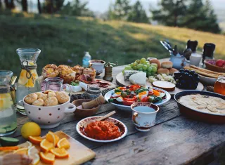 table en bois dans la campagne, avec de nombreux plats dessus