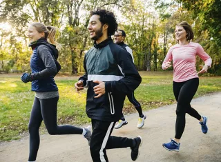 un groupe d’hommes et femmes font de la course à pied dans un parc